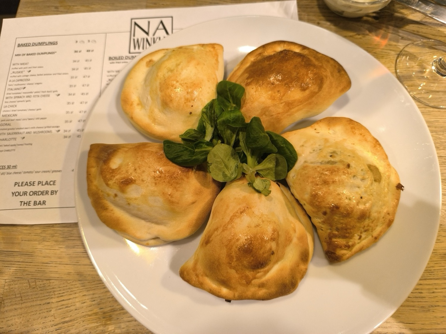 Pięć pierogów z pieca ułożonych na talerzu